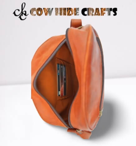Card slots and pen slots interior on tan leather sling bag