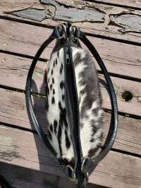 Black and white cowhide handbag with leather sides and zipper closure