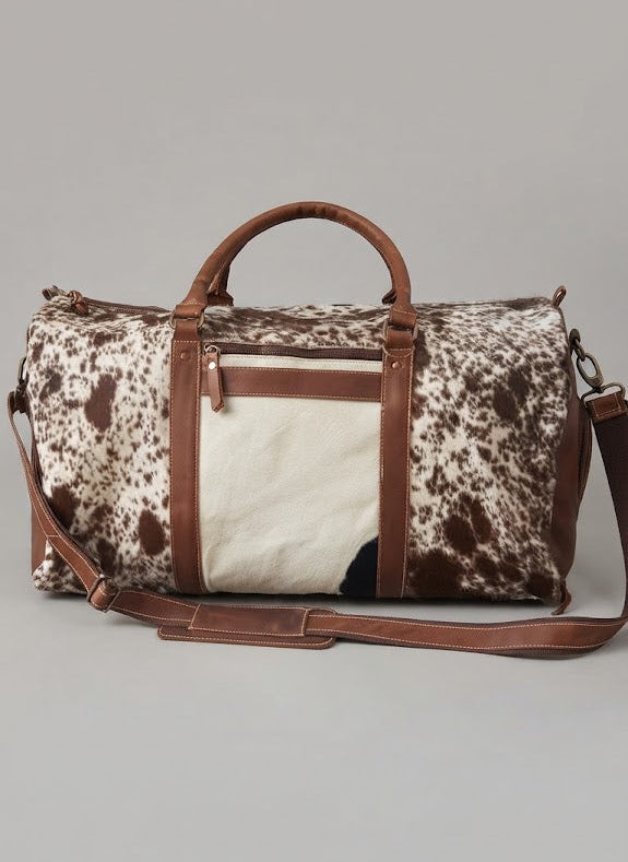 Brown and white cowhide duffle bag with leather panels
