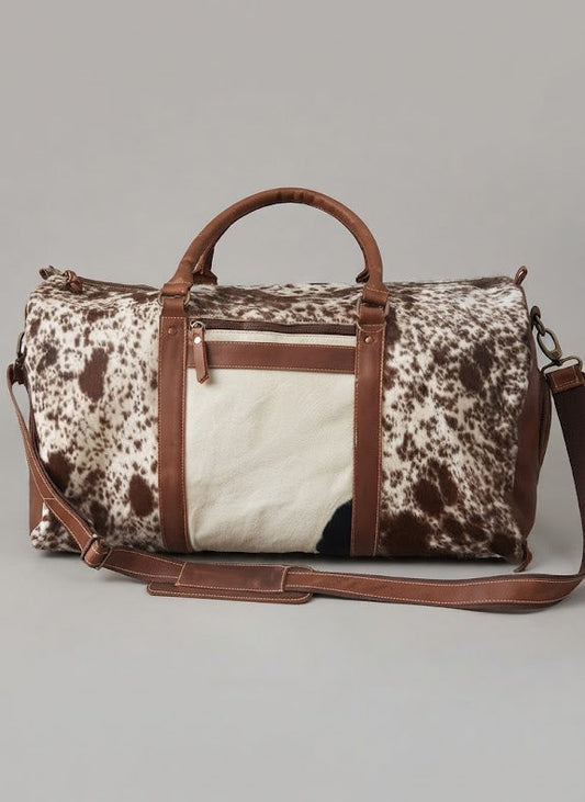 Brown and white cowhide duffle bag with leather panels