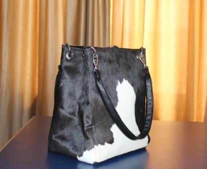 Black and white cowhide rectangle bucket leather bag with dual handles and magnetic closure