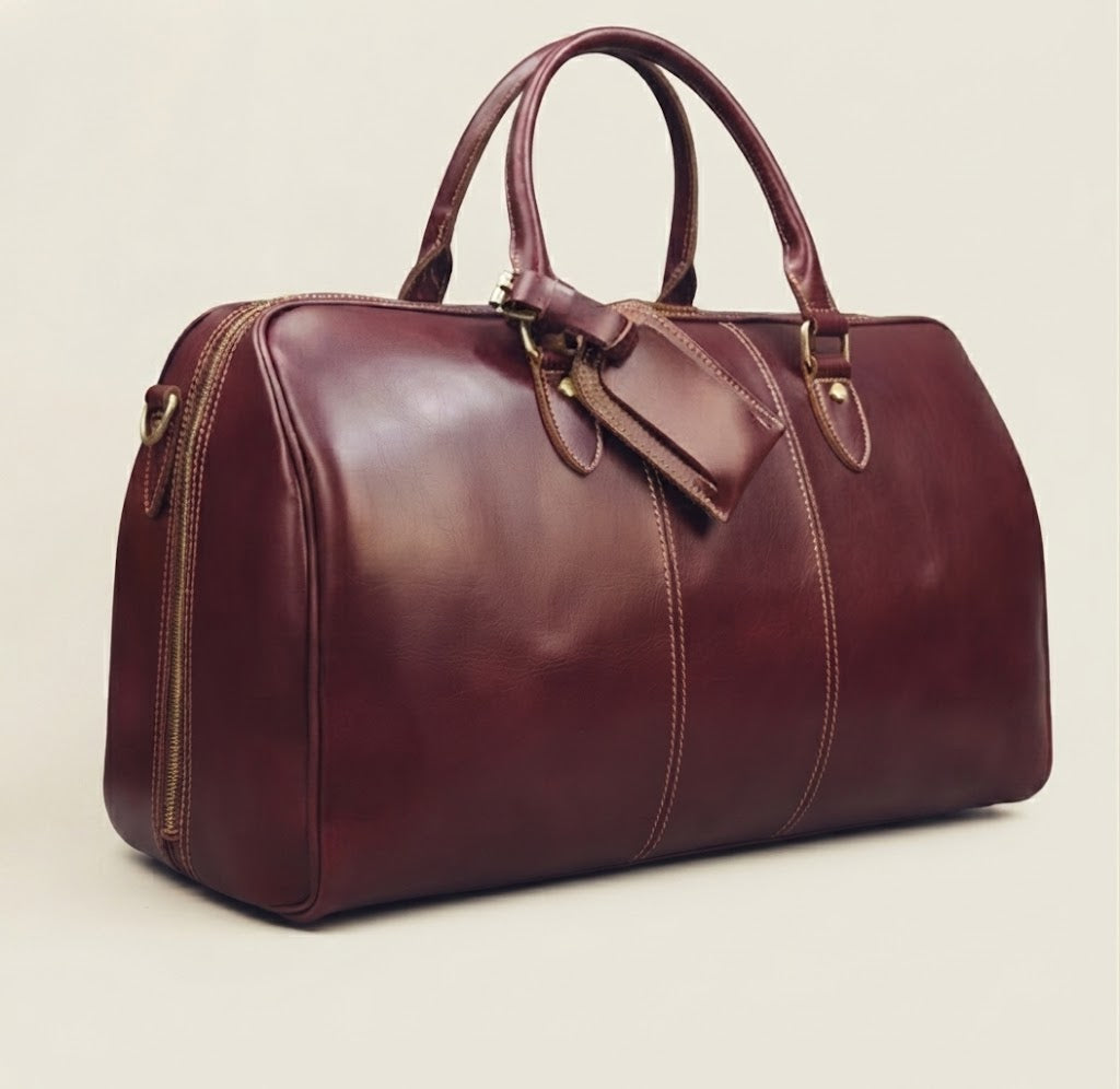 Removable leather luggage tag detail on burgundy duffle bag