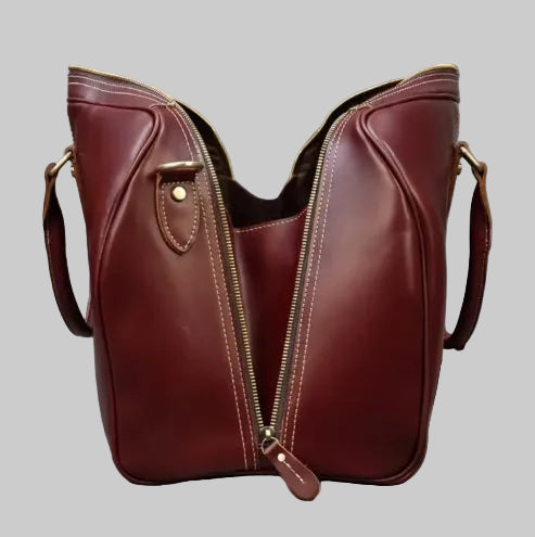 Wide-open zipper detail on burgundy leather duffle bag