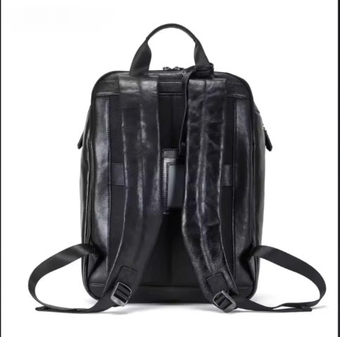 Rear tech compartment detail on matte black leather backpack