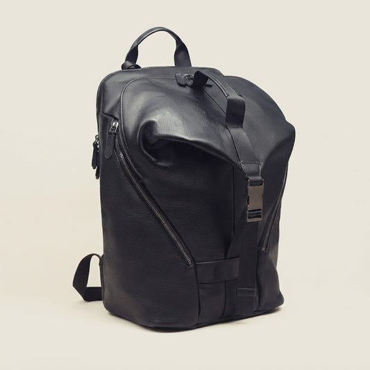 Roll-top compression strap and buckle detail on leather backpack