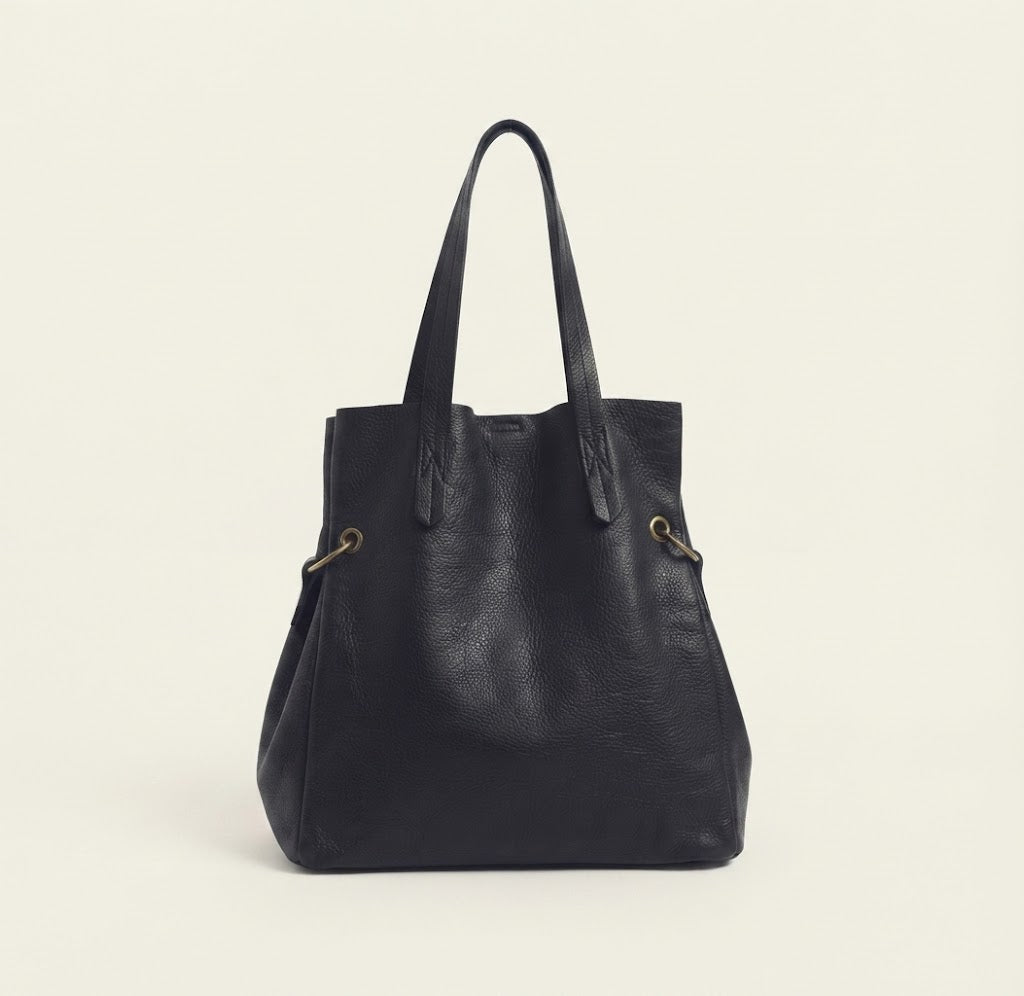 Adjustable crossbody strap detail on convertible bucket tote bag