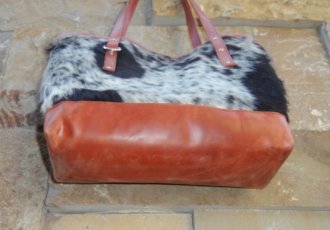 Back view of genuine black white hair-on cowhide bucket shopper bag with vintage tan leather