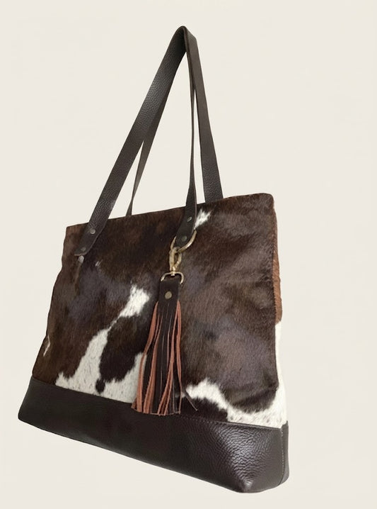 Cowhide fringe tote bag front view in dark brown speckled pattern