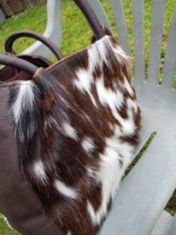 Side view of genuine brown white hair-on cowhide hobo shoulder bag showing 6 inch depth