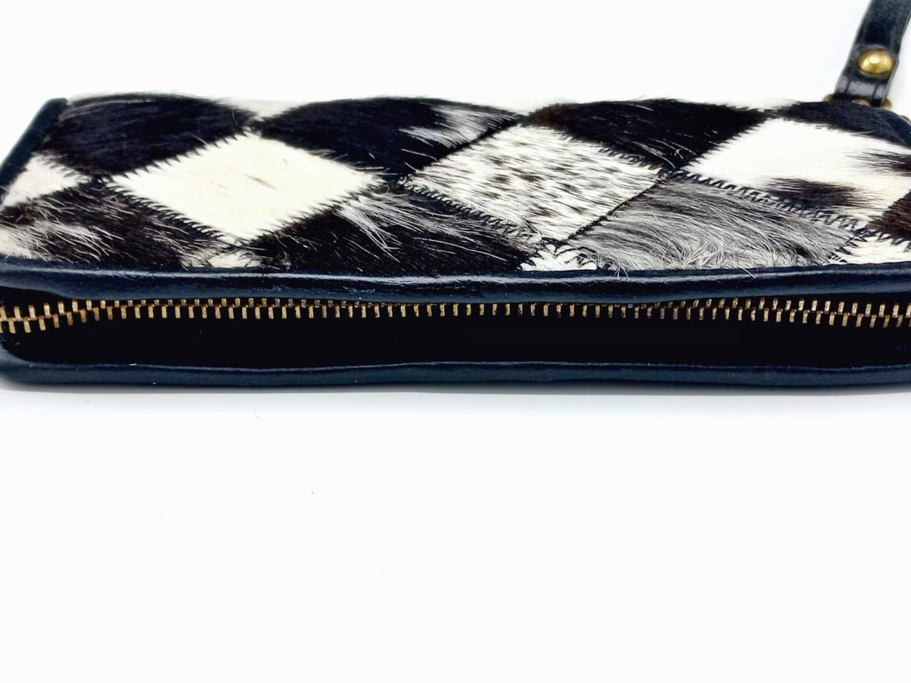 Full-length metal zipper closure detail on cowhide wallet