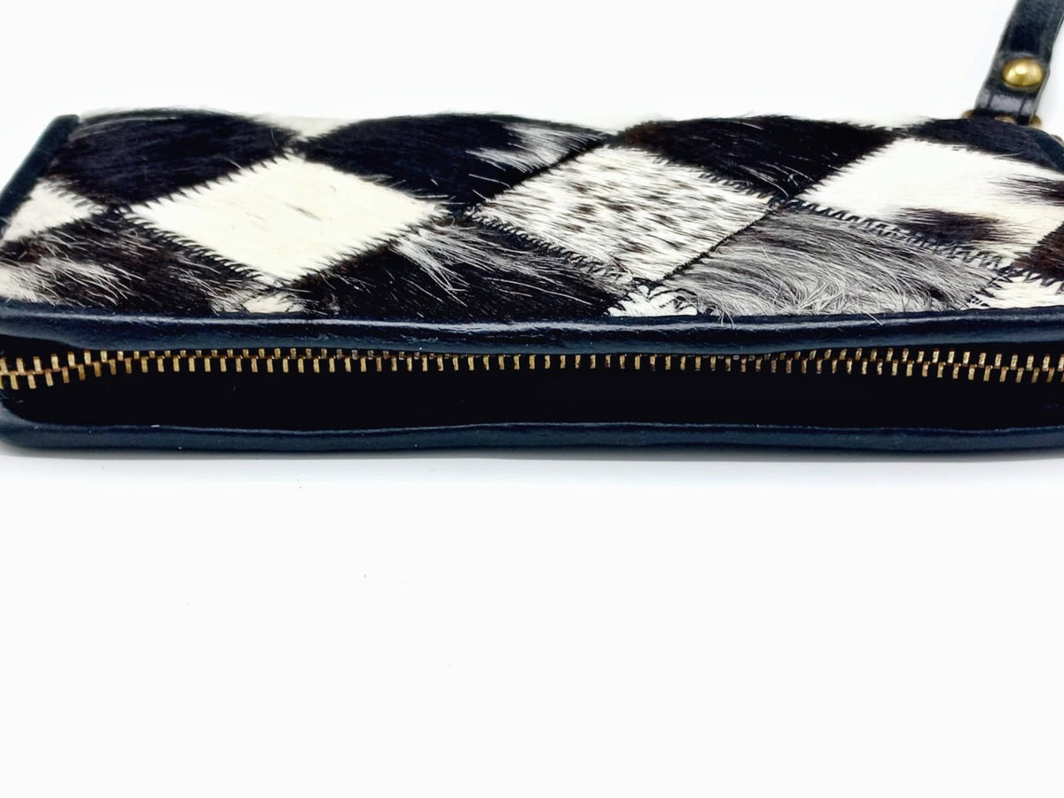 Full-length metal zipper closure detail on cowhide wallet
