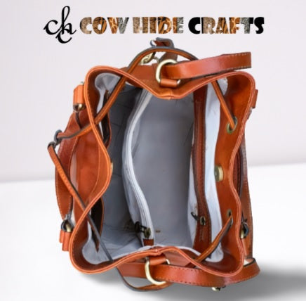 Drawstring and snap button closure on leather bucket bag