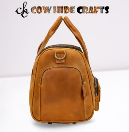 Dual handles and detachable strap on tan leather travel duffle