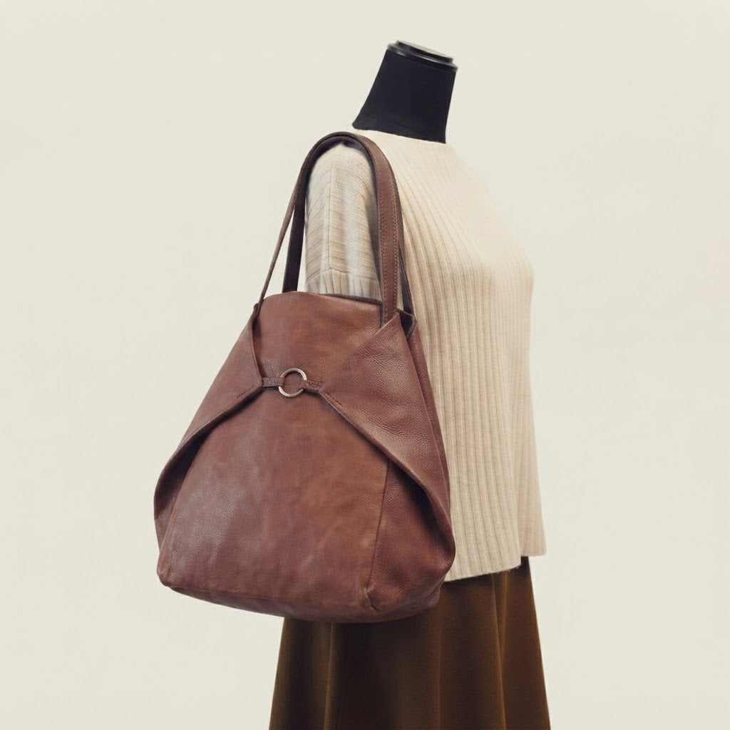 Leather tote folded into hobo shape via side tabs