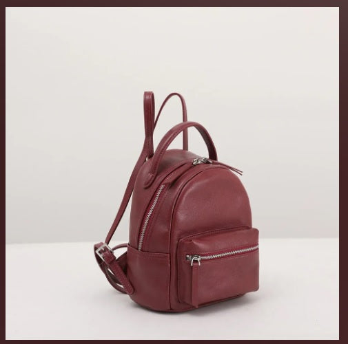 Dome-top zipper closure detail on leather mini backpack