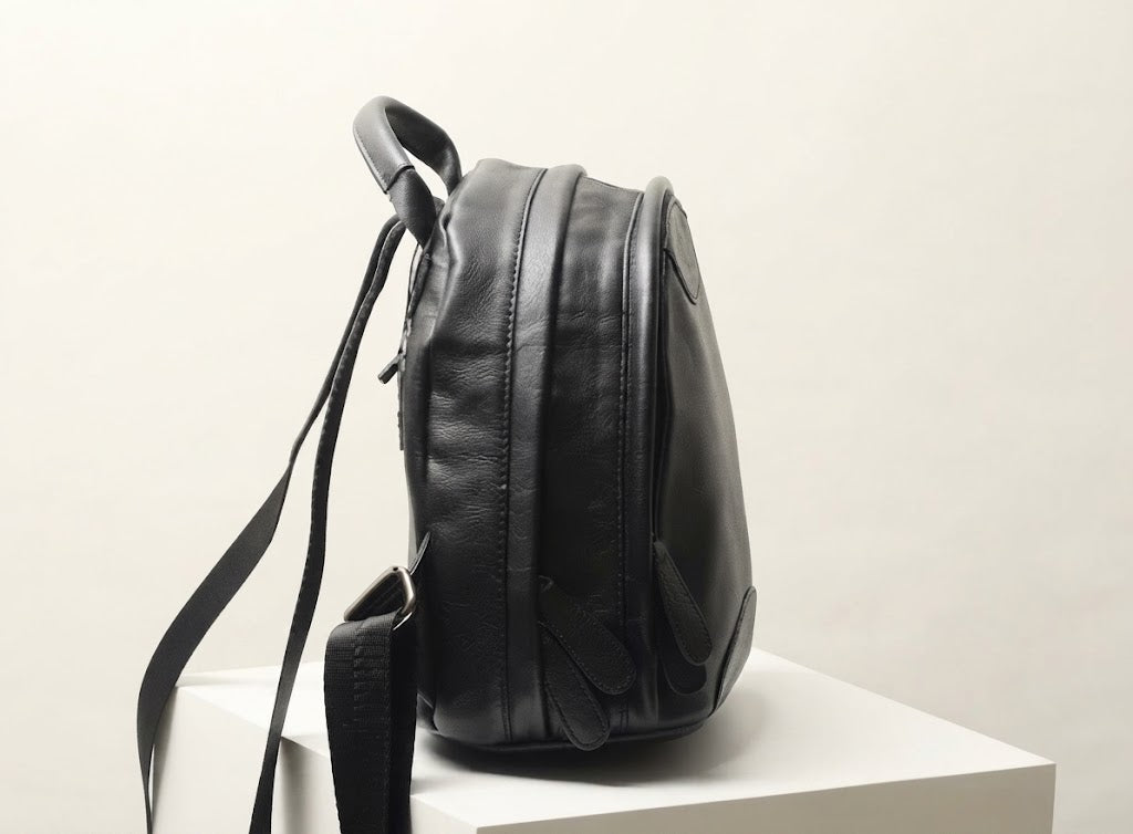 Dual parallel zipper compartment detail on leather backpack