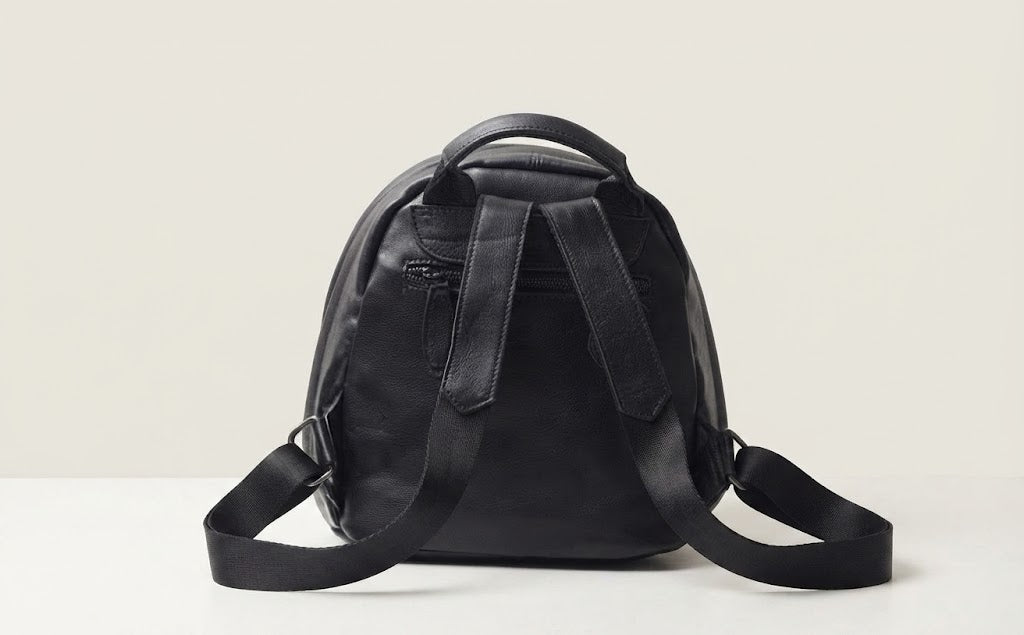 Fixed top handle and strap detail on multi-zipper leather backpack