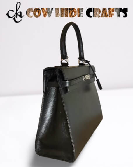 Single handle and flap toggle closure on black leather box bag