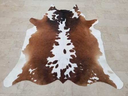 Brown and white cow rug